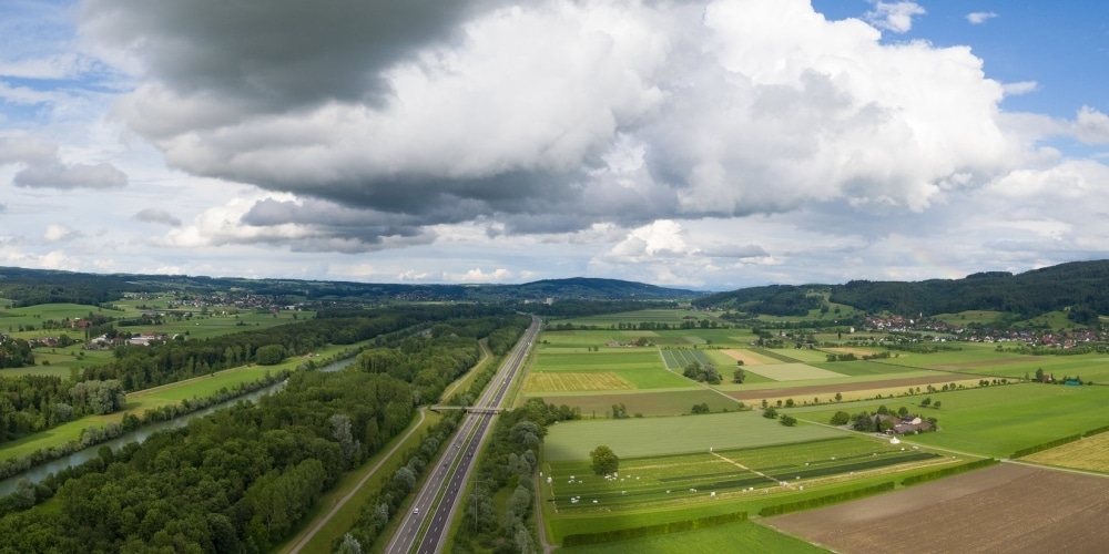 Drohnenaufnahme des Thurtals mit Thur, Autobahn, Wald, Äckern und Siedlungen.